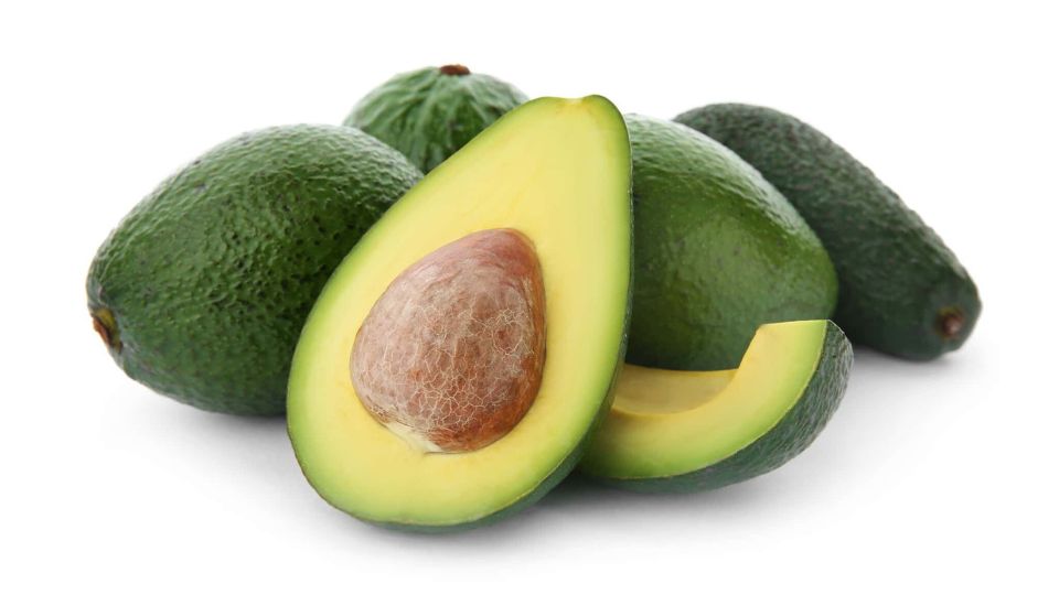 Avocado-Sorten, Pflanztipps und Krankheiten Reife Avocados, eine aufgeschnittene Frucht mit grünem Fruchtfleisch und Kern.