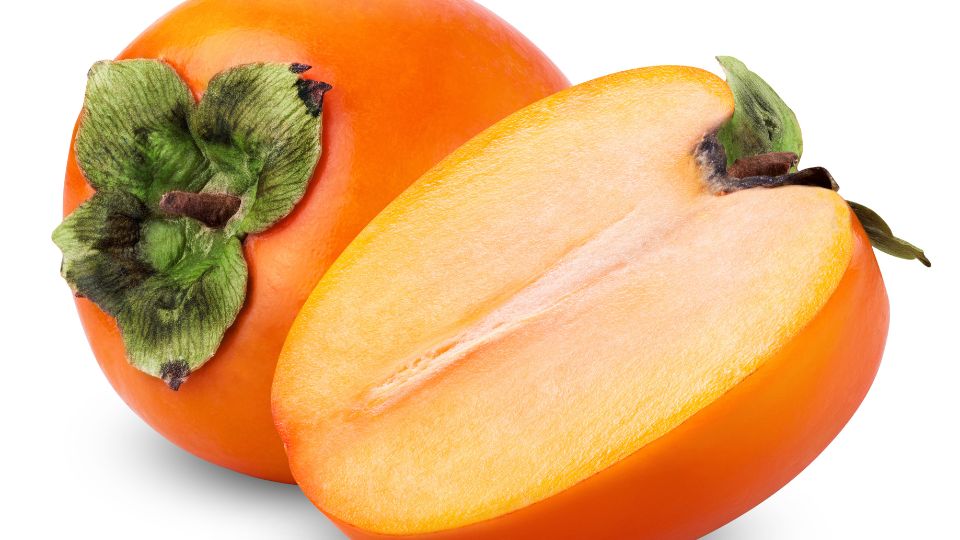Eine geschnittene Dattelpflaume zeigt ihr leuchtend orangefarbenes Fruchtfleisch.