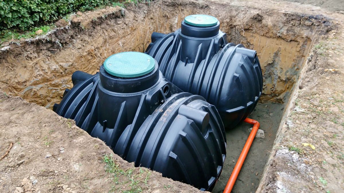 Zwei schwarze Zisternen im Erdreich, bereit zur Regenwassernutzung im Garten.