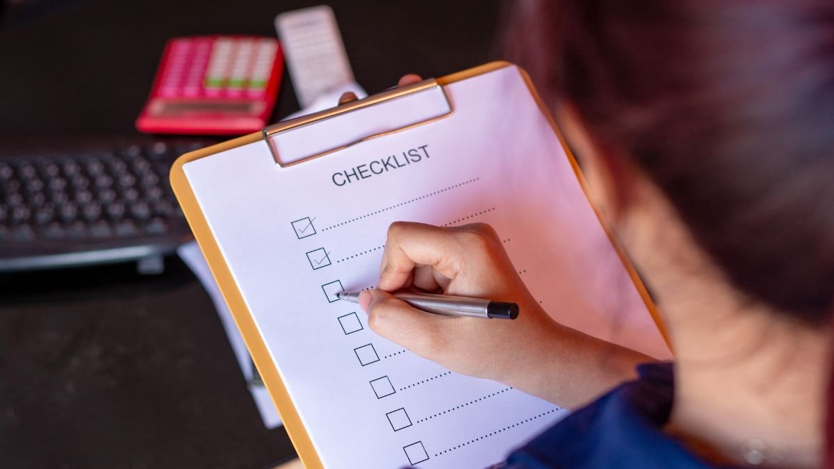 Eine Person kreuzt Aufgaben auf einer Checkliste für den Herbstgarten ab.