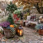 Herbstlich dekorierter Garten mit winterfesten Pflanzen, Laternen und natürlichen Materialien